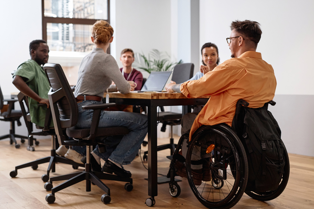 business people in a meeting with one man sat in a wheelchair