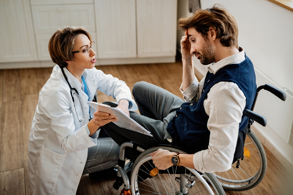 Doctor talking to a man in a wheelchair